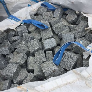 Packing natural split setts from grey granite 10x10x5 in big bags