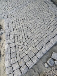 Laying of tumbled paving stones made of black Gabbro stone