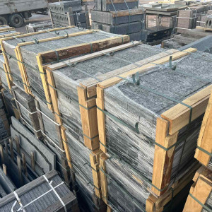 The black stone paving stones are packed in wooden battens