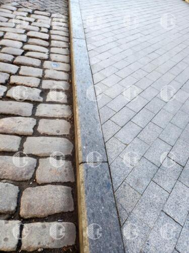 Curb of medium-grained gray granite with yellowish-beige blotches